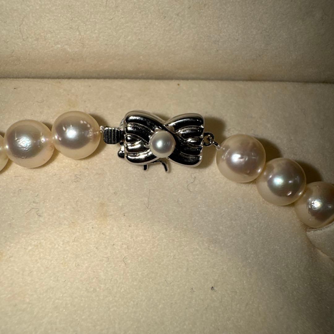 Tasaki pearl necklace with ribbon clasp measuring 43.5 centimeters displayed on white background