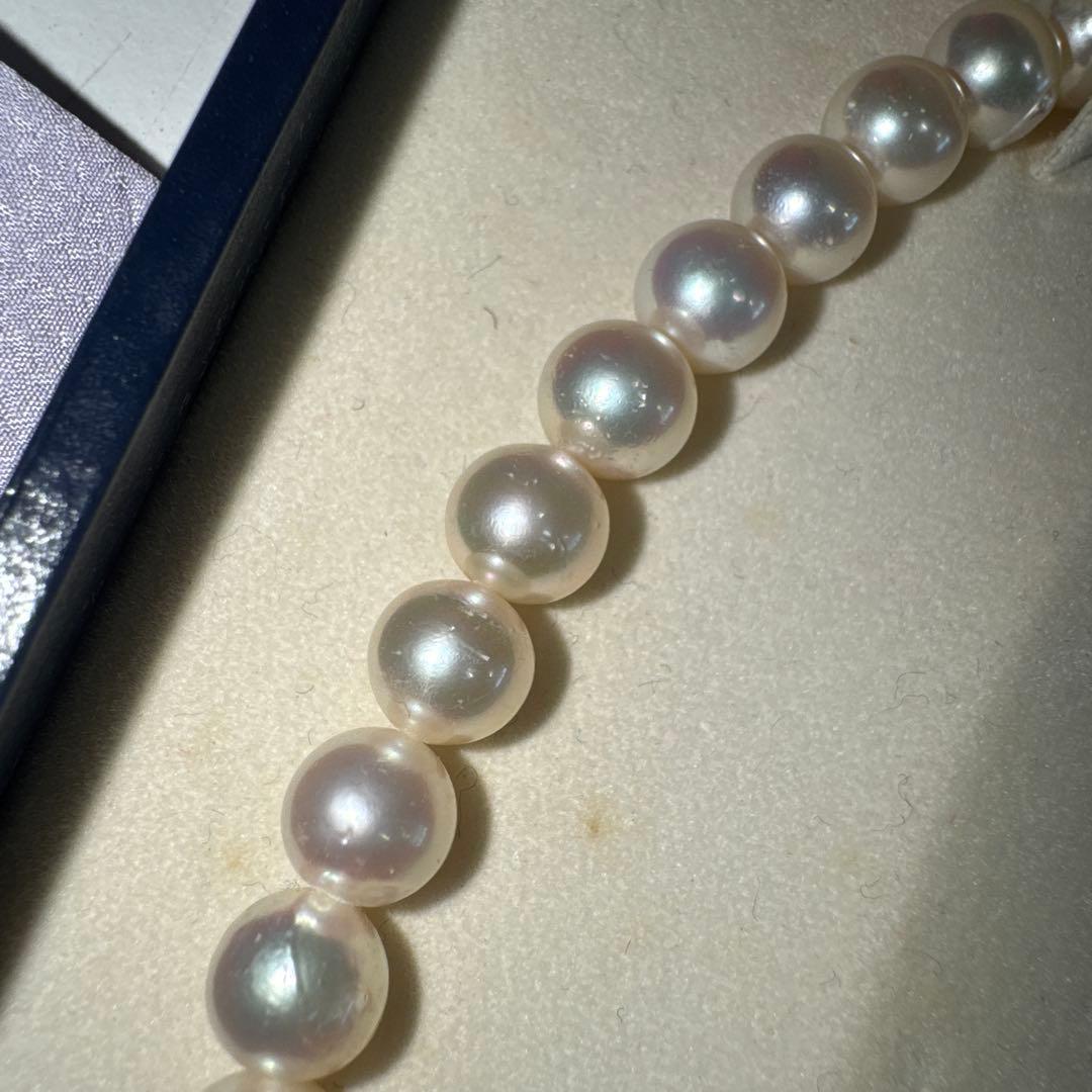 Tasaki pearl necklace with ribbon clasp measuring 43.5 centimeters displayed on white background