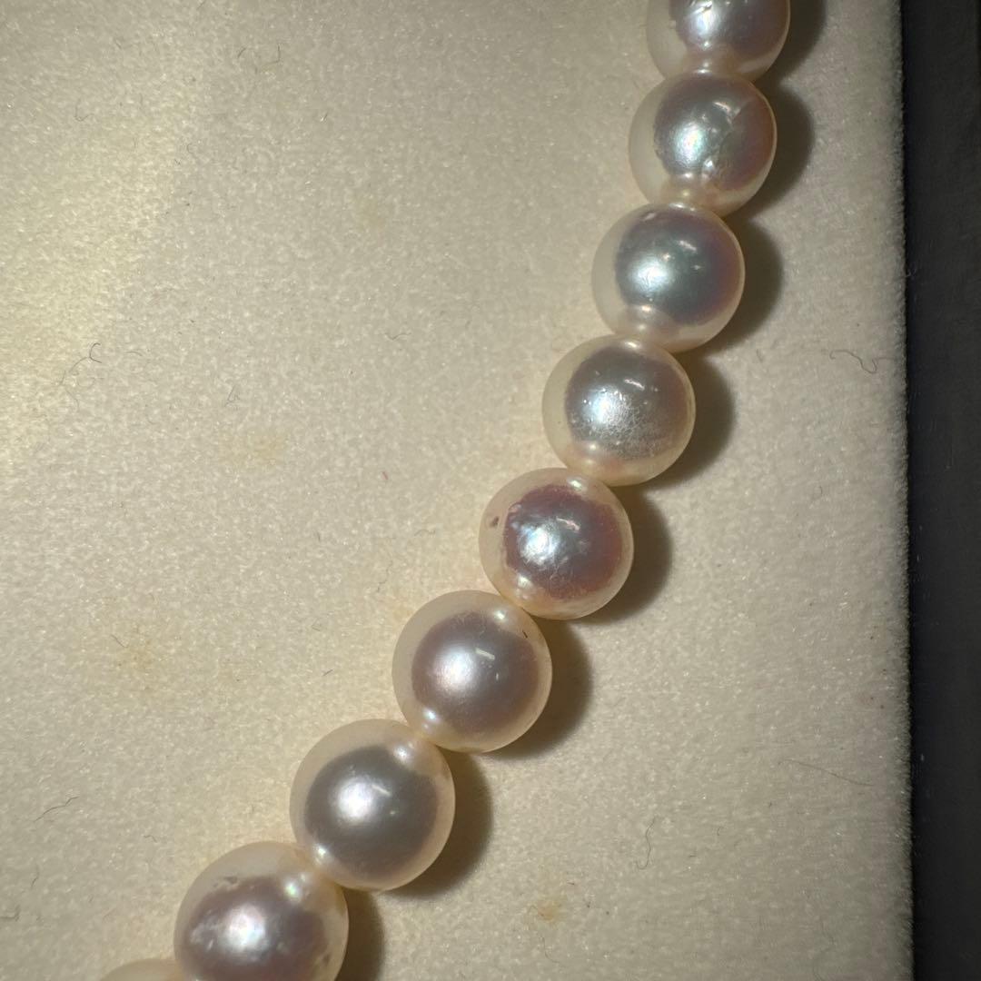 Tasaki pearl necklace with ribbon clasp measuring 43.5 centimeters displayed on white background