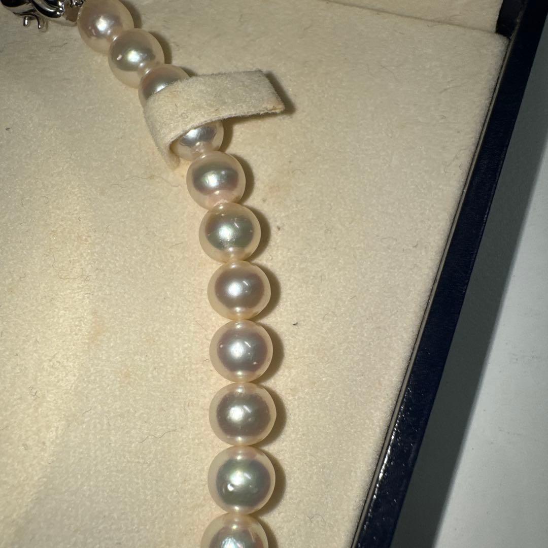 Tasaki pearl necklace with ribbon clasp measuring 43.5 centimeters displayed on white background