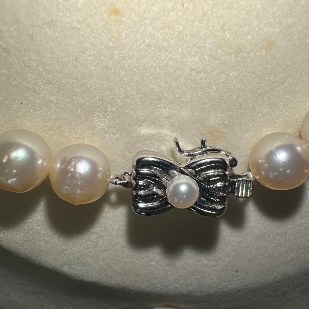 Tasaki pearl necklace with ribbon clasp measuring 43.5 centimeters displayed on white background