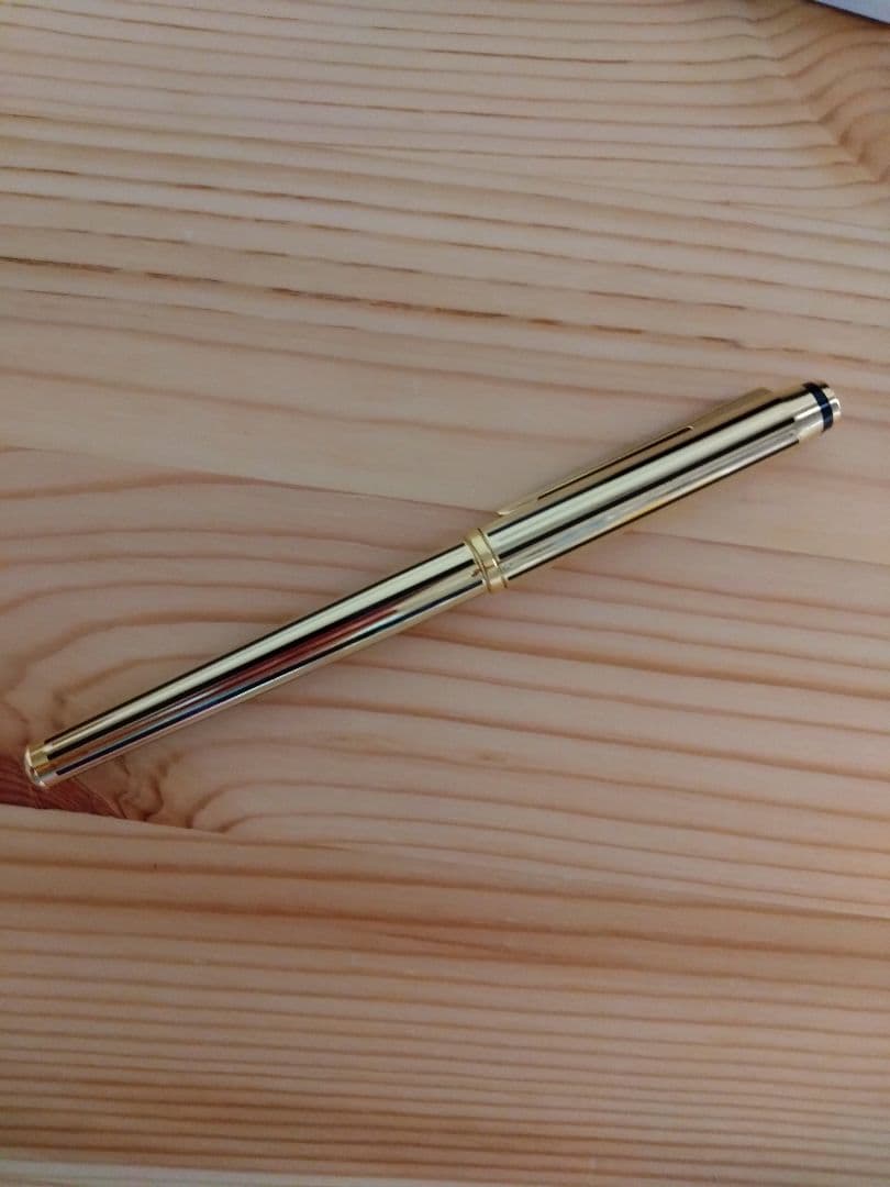 Used CROSS Selectip rolling ball pen in 22K gold with black lacquer finish and visible dent on pen body