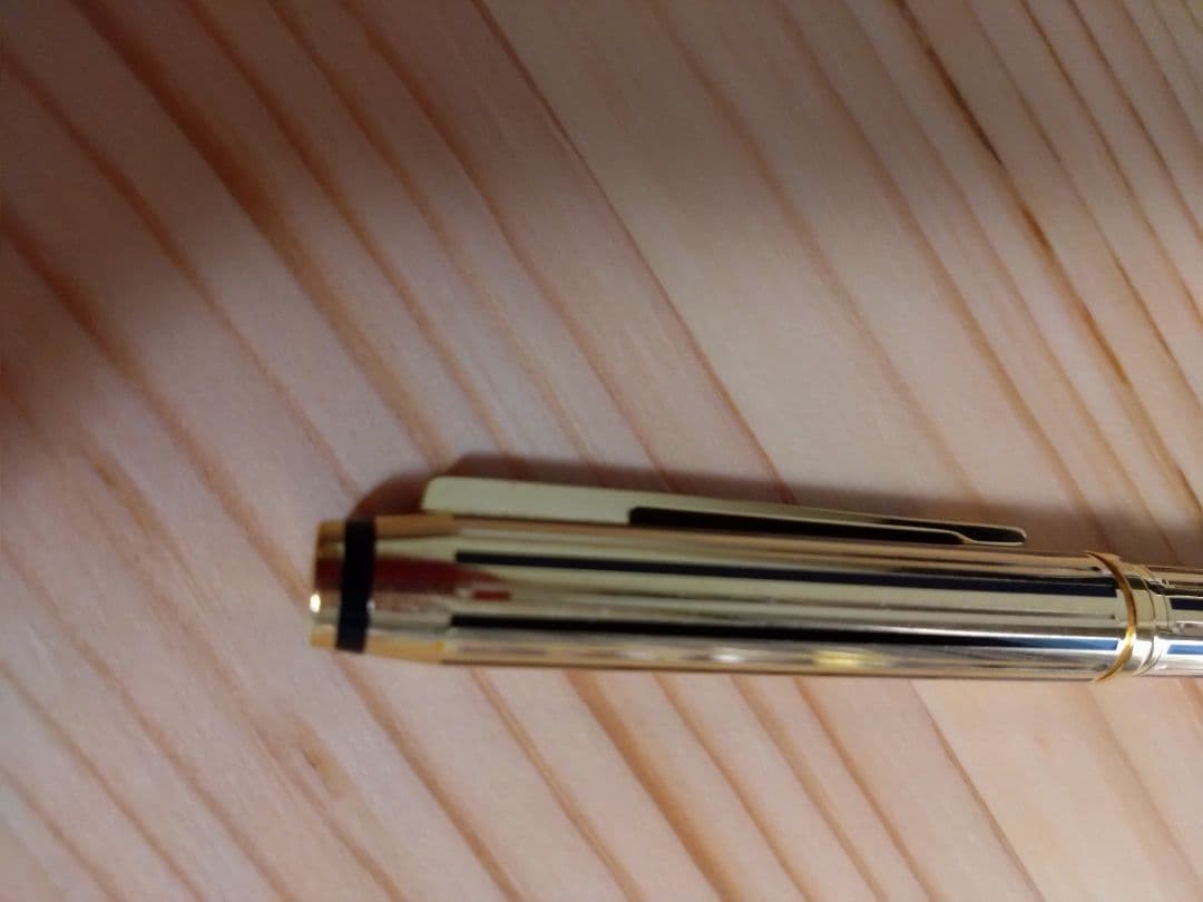 Used CROSS Selectip rolling ball pen in 22K gold with black lacquer finish and visible dent on pen body