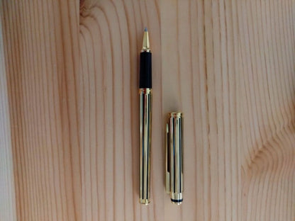 Used CROSS Selectip rolling ball pen in 22K gold with black lacquer finish and visible dent on pen body
