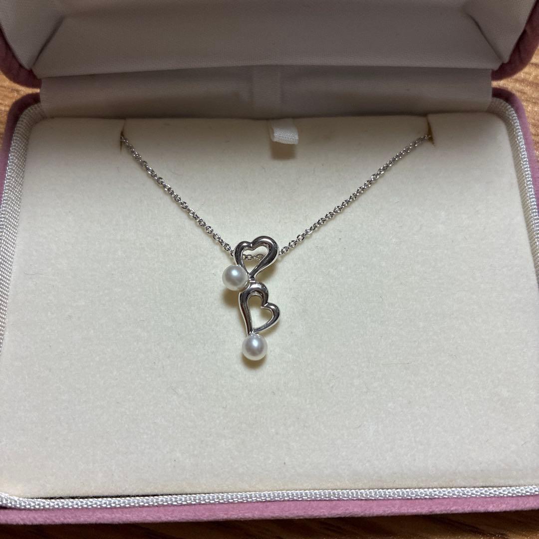 Tasaki freshwater pearl pendant set in silver displayed on a white background