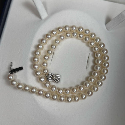 Tasaki Akoya pearl necklace with 6.5-7mm pearls and ribbon clasp displayed with jewelry box