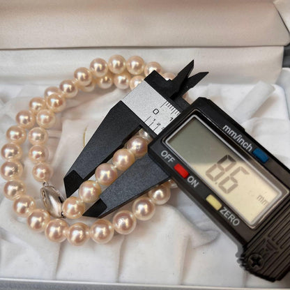 Akoya pearl necklace with white pearls sized 8.6 to 9.0mm and silver metal clasp on a white background