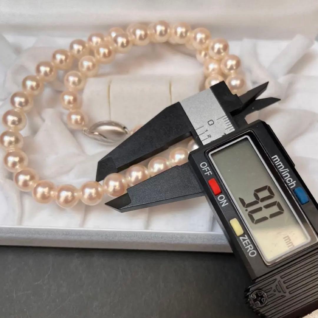 Akoya pearl necklace with white pearls sized 8.6 to 9.0mm and silver metal clasp on a white background