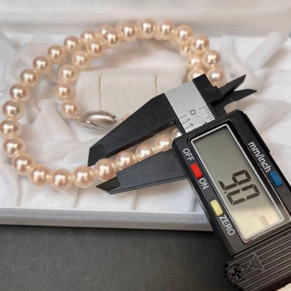 Akoya pearl necklace with white pearls sized 8.6 to 9.0mm and silver metal clasp on a white background