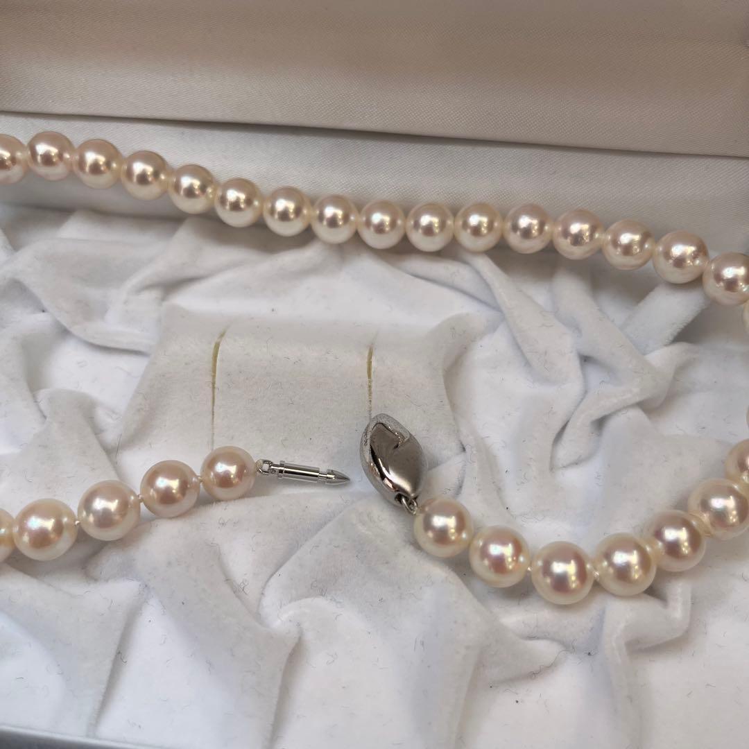 Akoya pearl necklace with white pearls sized 8.6 to 9.0mm and silver metal clasp on a white background
