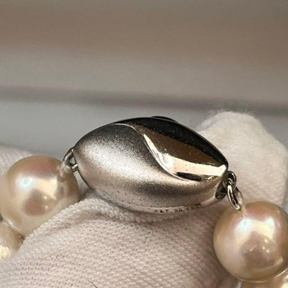 Akoya pearl necklace with white pearls sized 8.6 to 9.0mm and silver metal clasp on a white background