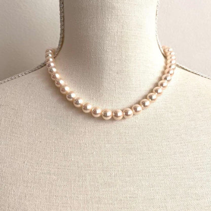 Akoya pearl necklace with white pearls sized 8.6 to 9.0mm and silver metal clasp on a white background