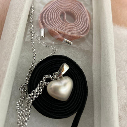 Tasaki Pearl Heart Necklace with pearl pendant and pink and black velvet ribbon set on white background