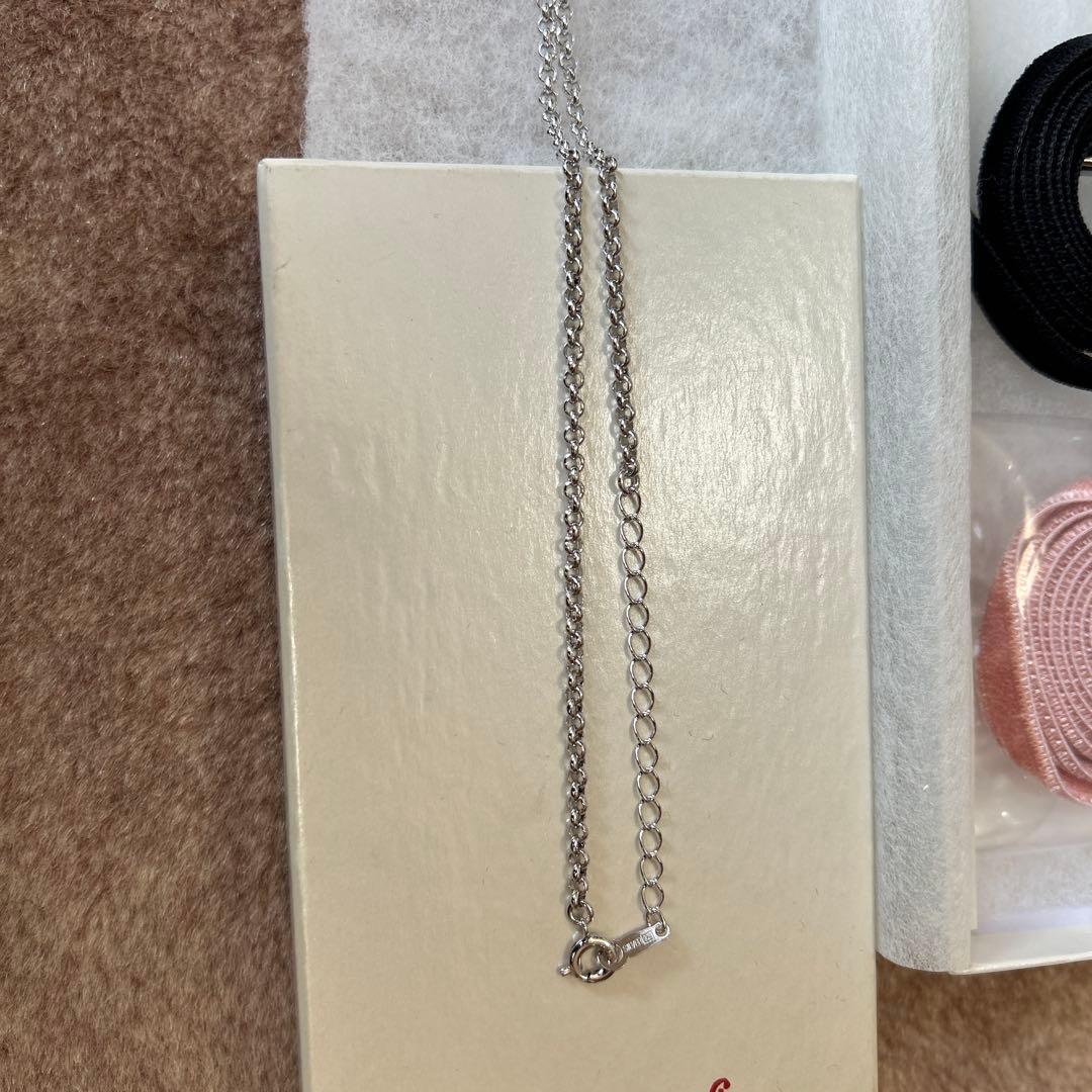 Tasaki Pearl Heart Necklace with pearl pendant and pink and black velvet ribbon set on white background