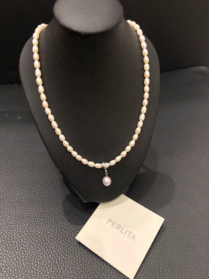 PERLITA Mikimoto pearl necklace featuring a pink pearl on a white pearl strand with dedicated case and outer box