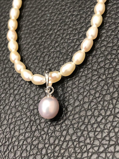PERLITA Mikimoto pearl necklace featuring a pink pearl on a white pearl strand with dedicated case and outer box