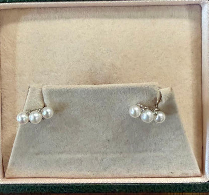 Pearl necklace adorned with sparkling diamonds displayed on a white background