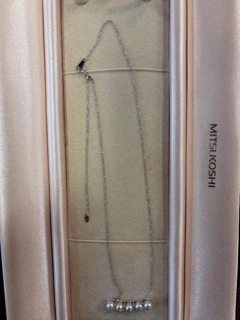 Pearl necklace adorned with sparkling diamonds displayed on a white background