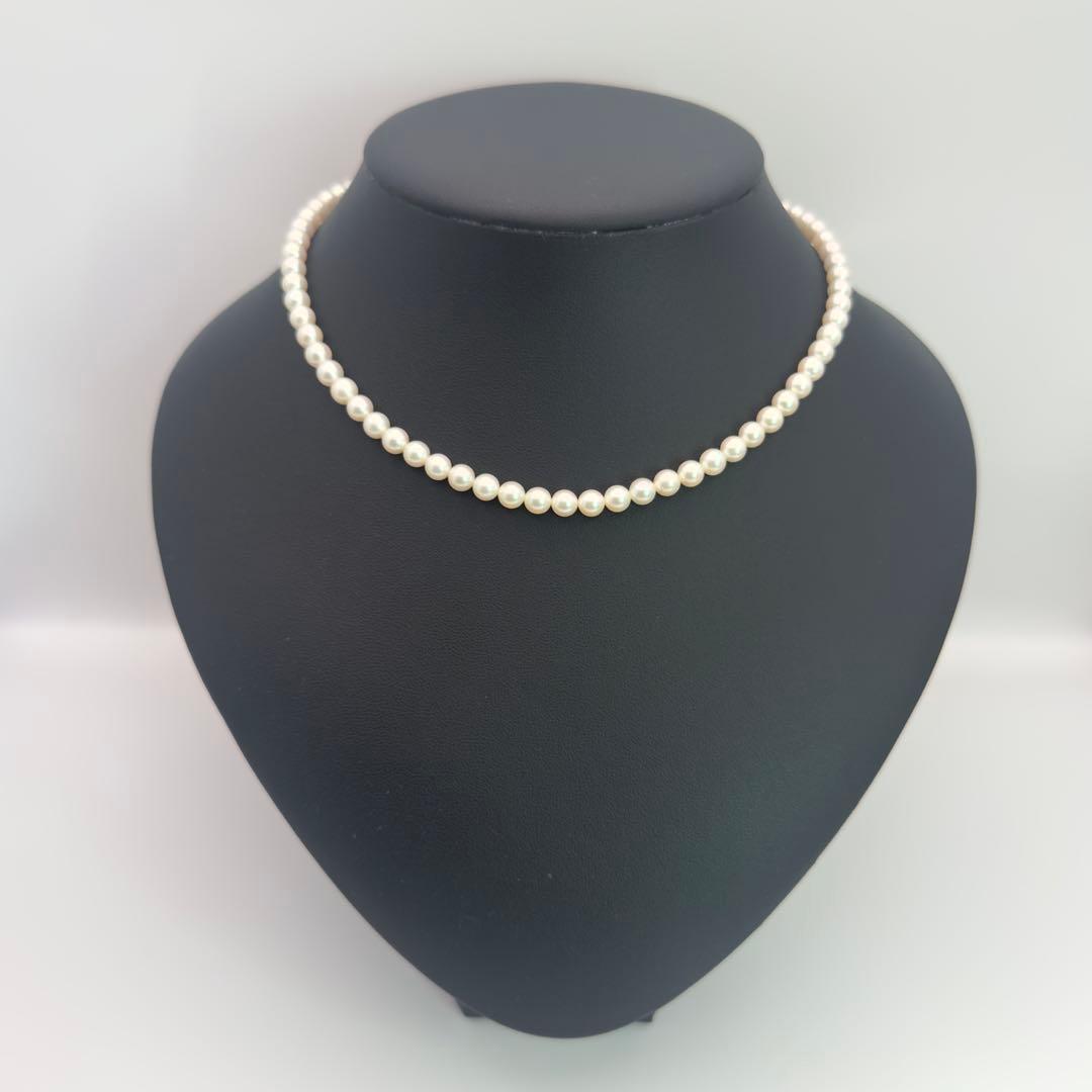 MIKIMOTO pearl necklace made of silver with round white pearls on a white background
