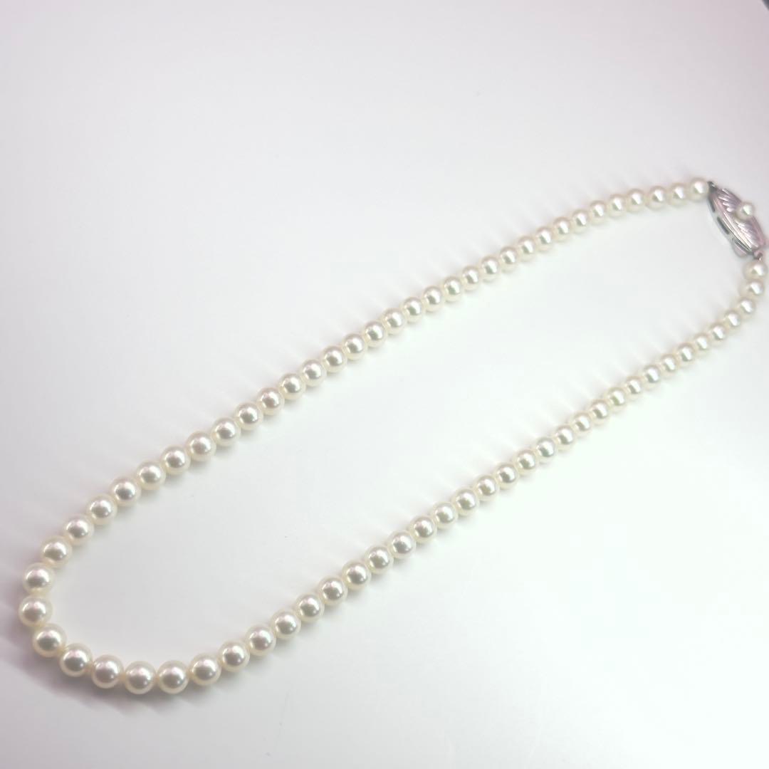 MIKIMOTO pearl necklace made of silver with round white pearls on a white background