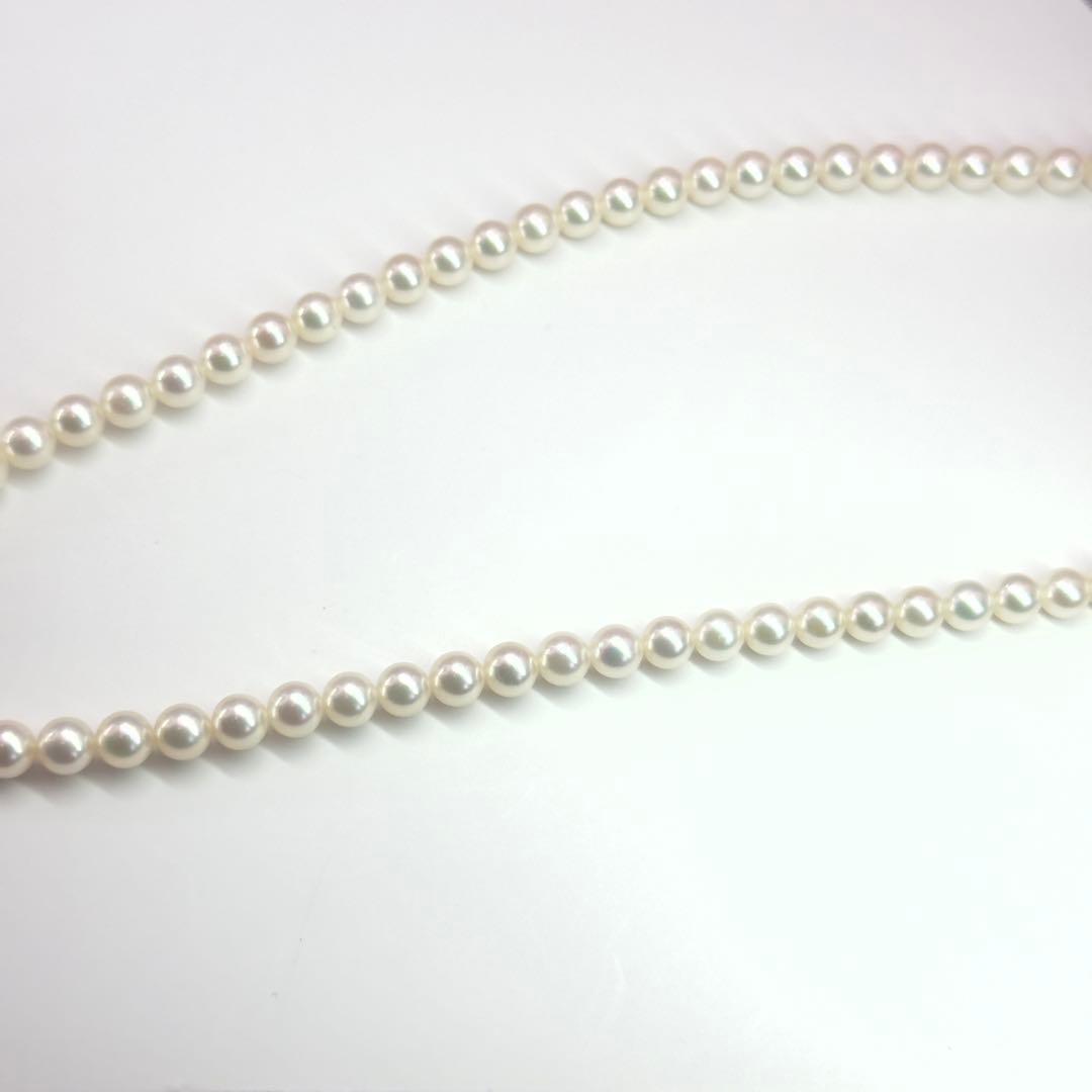 MIKIMOTO pearl necklace made of silver with round white pearls on a white background