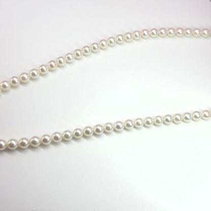 MIKIMOTO pearl necklace made of silver with round white pearls on a white background