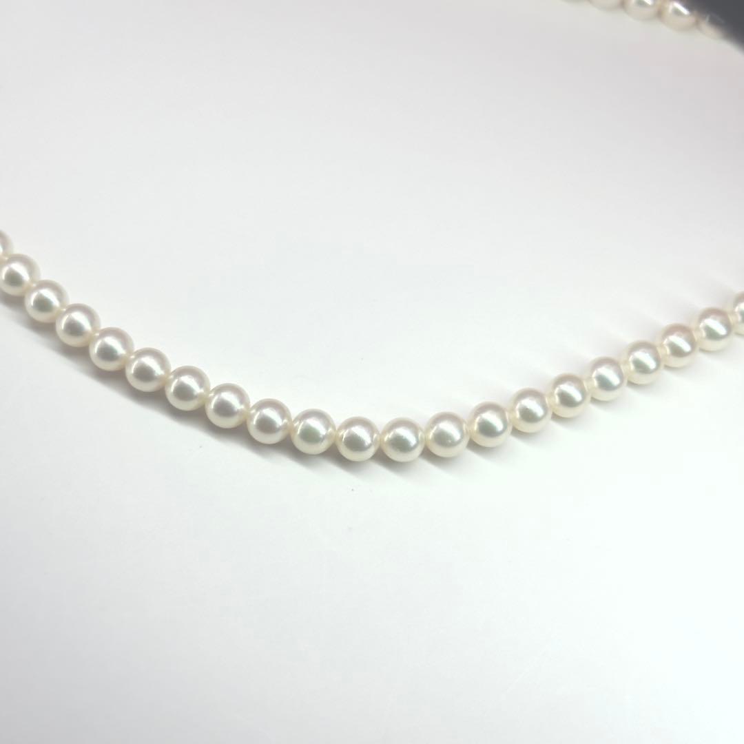 MIKIMOTO pearl necklace made of silver with round white pearls on a white background