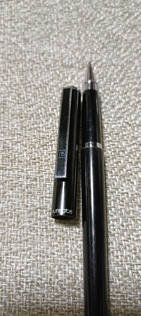 Pilot Laureate black and silver water-based ballpoint pen with cap on, showing light scratches and good condition