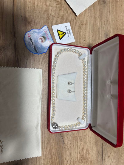 Tasaki pearl necklace and matching earrings set displayed on a white background