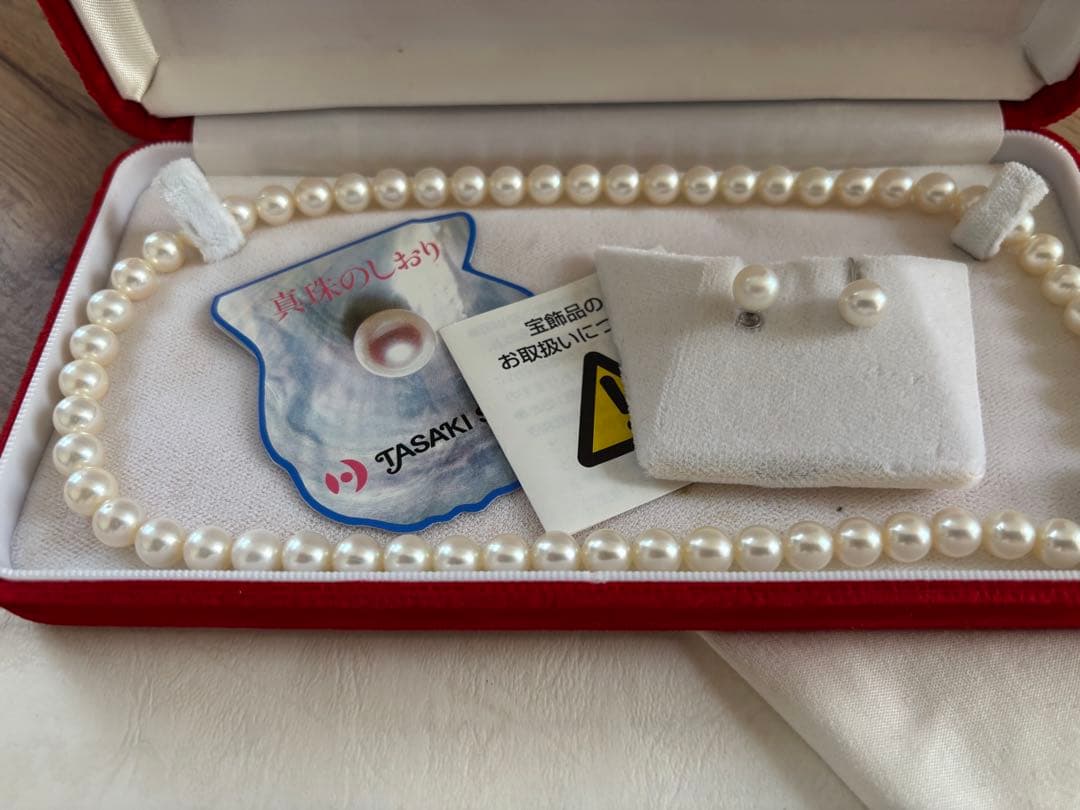 Tasaki pearl necklace and matching earrings set displayed on a white background