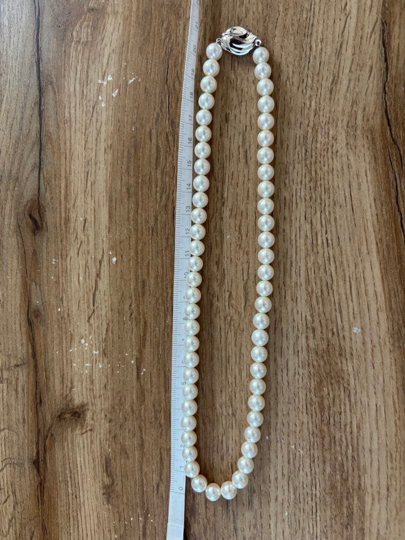 Tasaki pearl necklace and matching earrings set displayed on a white background