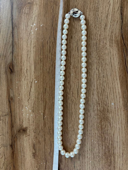 Tasaki pearl necklace and matching earrings set displayed on a white background