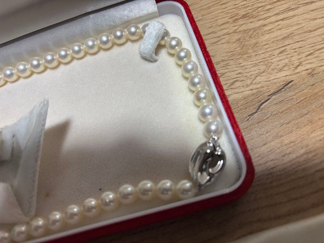 Tasaki pearl necklace and matching earrings set displayed on a white background