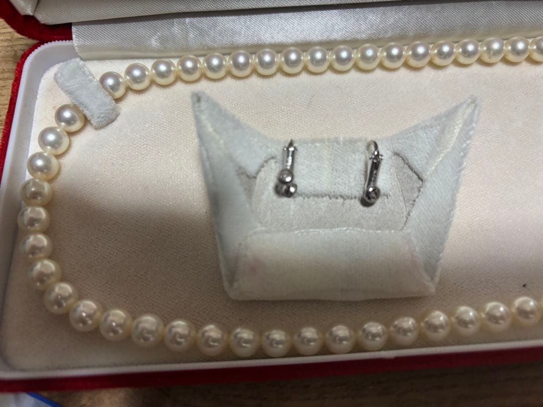Tasaki pearl necklace and matching earrings set displayed on a white background