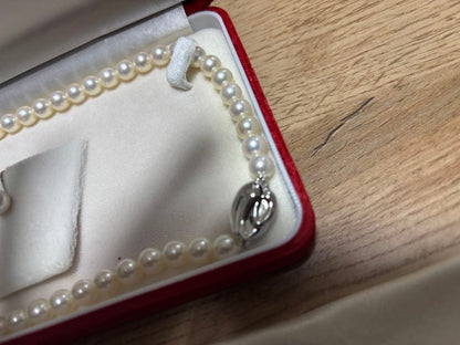 Tasaki pearl necklace and matching earrings set displayed on a white background