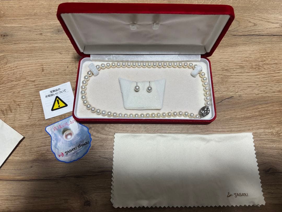 Tasaki pearl necklace and matching earrings set displayed on a white background