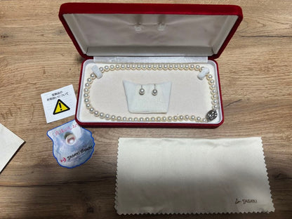 Tasaki pearl necklace and matching earrings set displayed on a white background