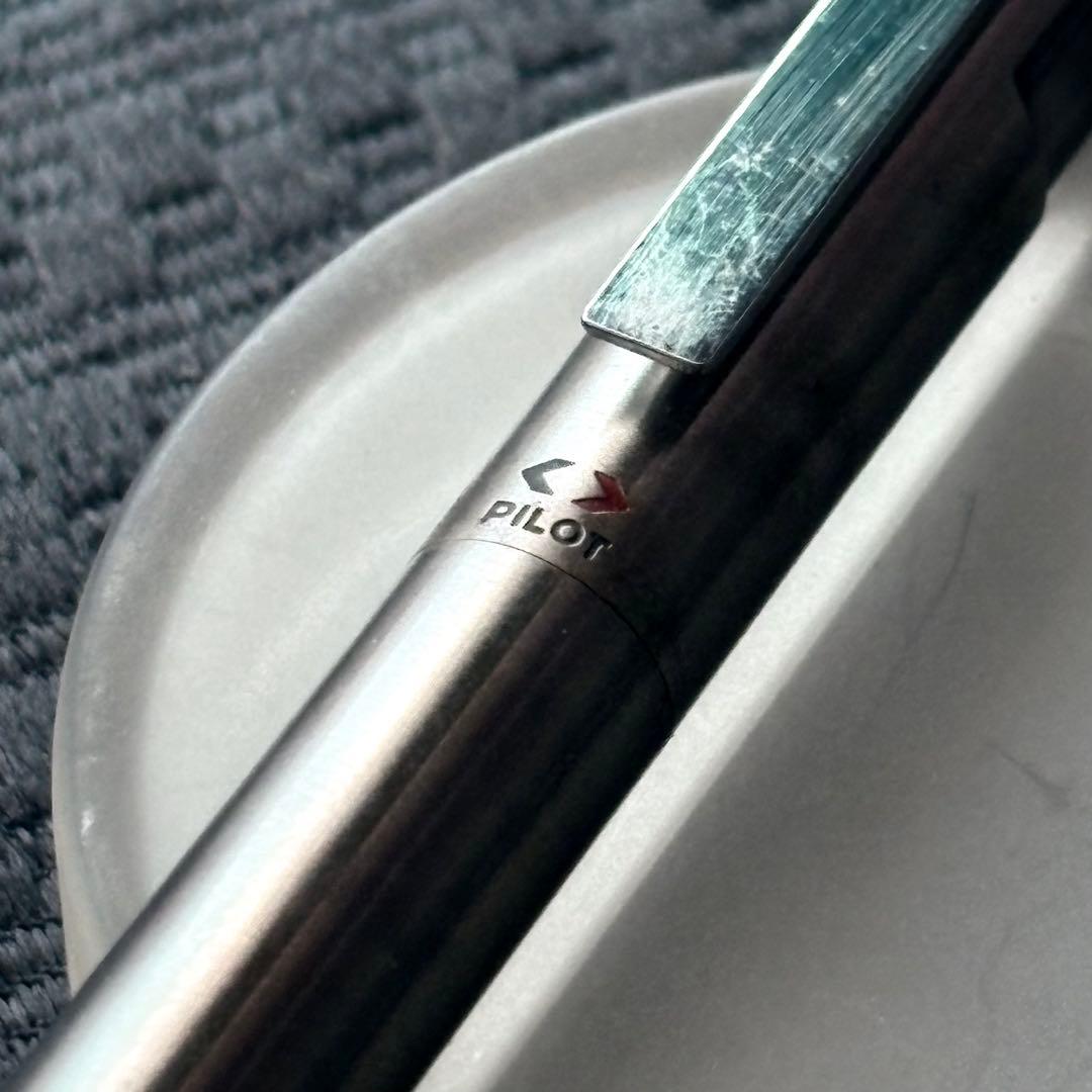 Pilot Quartz Pen in two colors with multi-function features and an included watch showing signs of wear