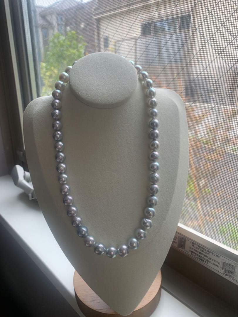 Akoya pearl necklace with natural blue pearls sized 9 to 10 millimeters arranged on a white background