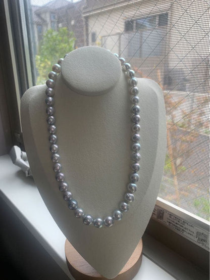 Akoya pearl necklace with natural blue pearls sized 9 to 10 millimeters arranged on a white background