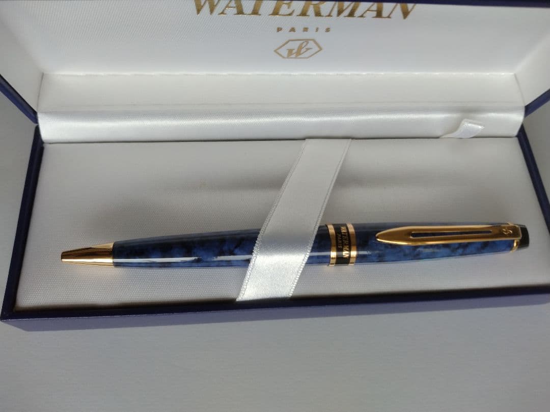 Waterman ballpoint pen in blue marble pattern with gold trim and twist mechanism, displayed with dedicated case