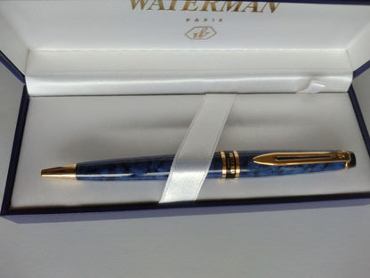 Waterman ballpoint pen in blue marble pattern with gold trim and twist mechanism, displayed with dedicated case