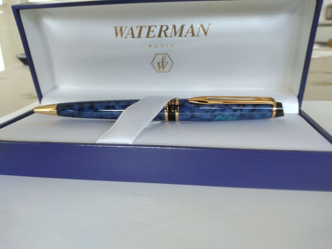 Waterman ballpoint pen in blue marble pattern with gold trim and twist mechanism, displayed with dedicated case