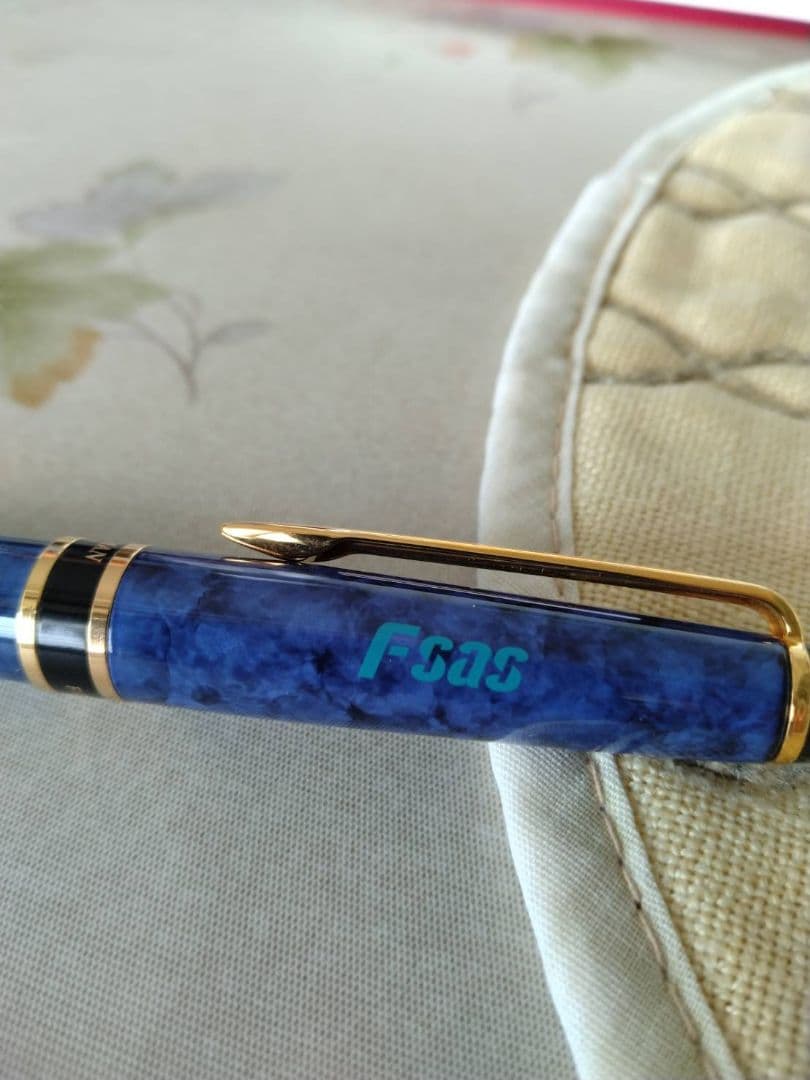 Waterman ballpoint pen in blue marble pattern with gold trim and twist mechanism, displayed with dedicated case