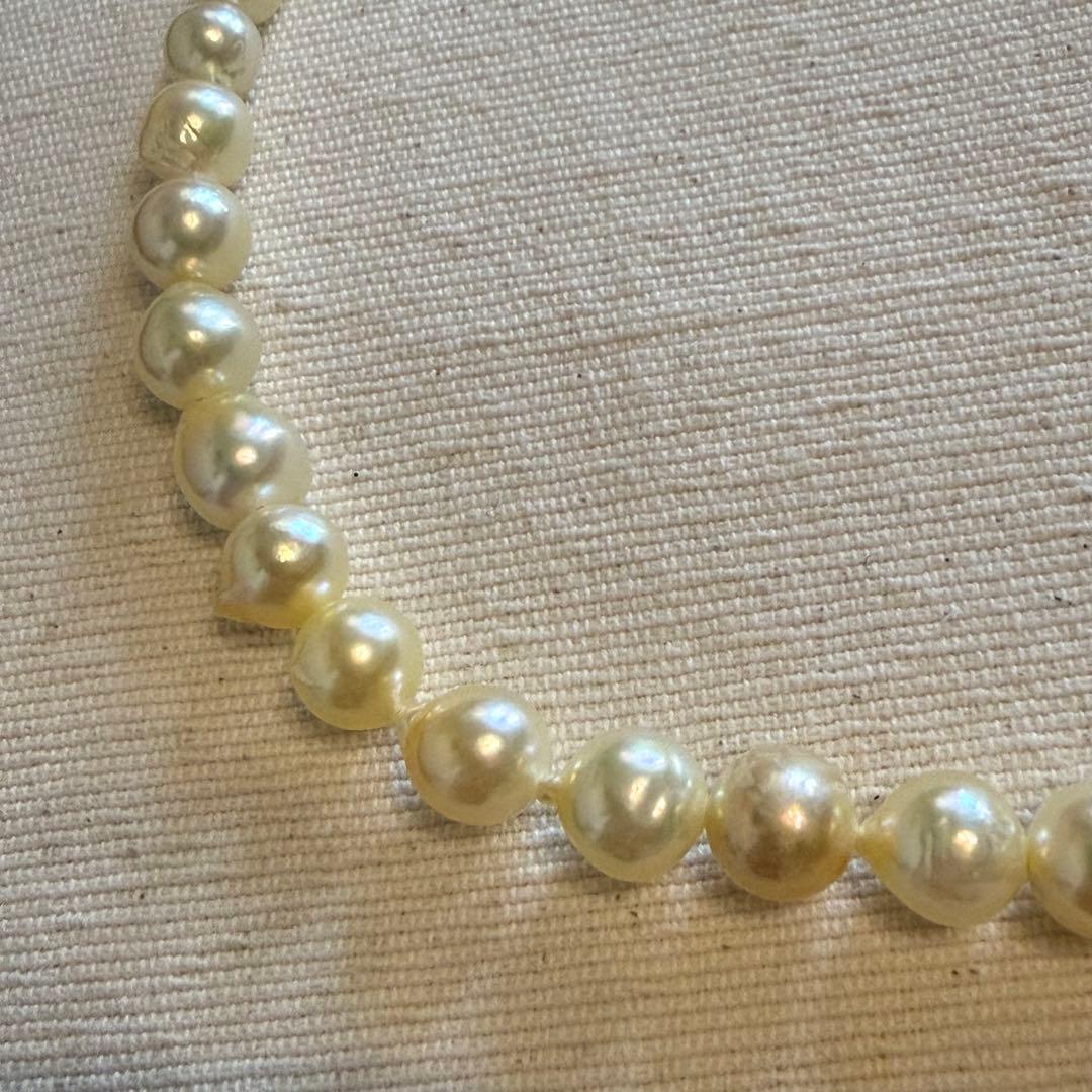 Akoya pearl choker necklace with white to yellow pearls, irregular shapes, 39 cm length, and larger center pearl