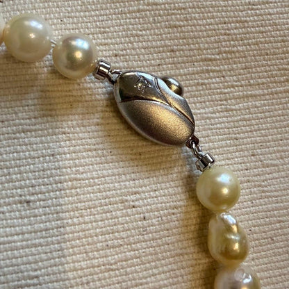Akoya pearl choker necklace with white to yellow pearls, irregular shapes, 39 cm length, and larger center pearl