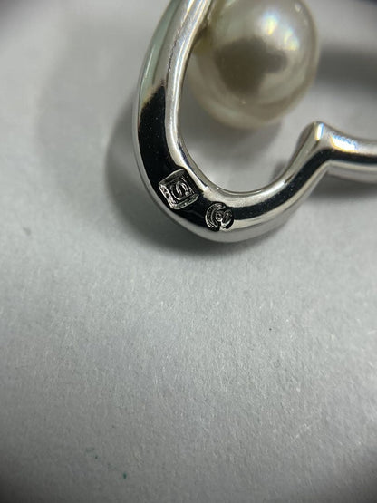 Silver color necklace featuring a heart motif decorated with a pearl and a hook clasp