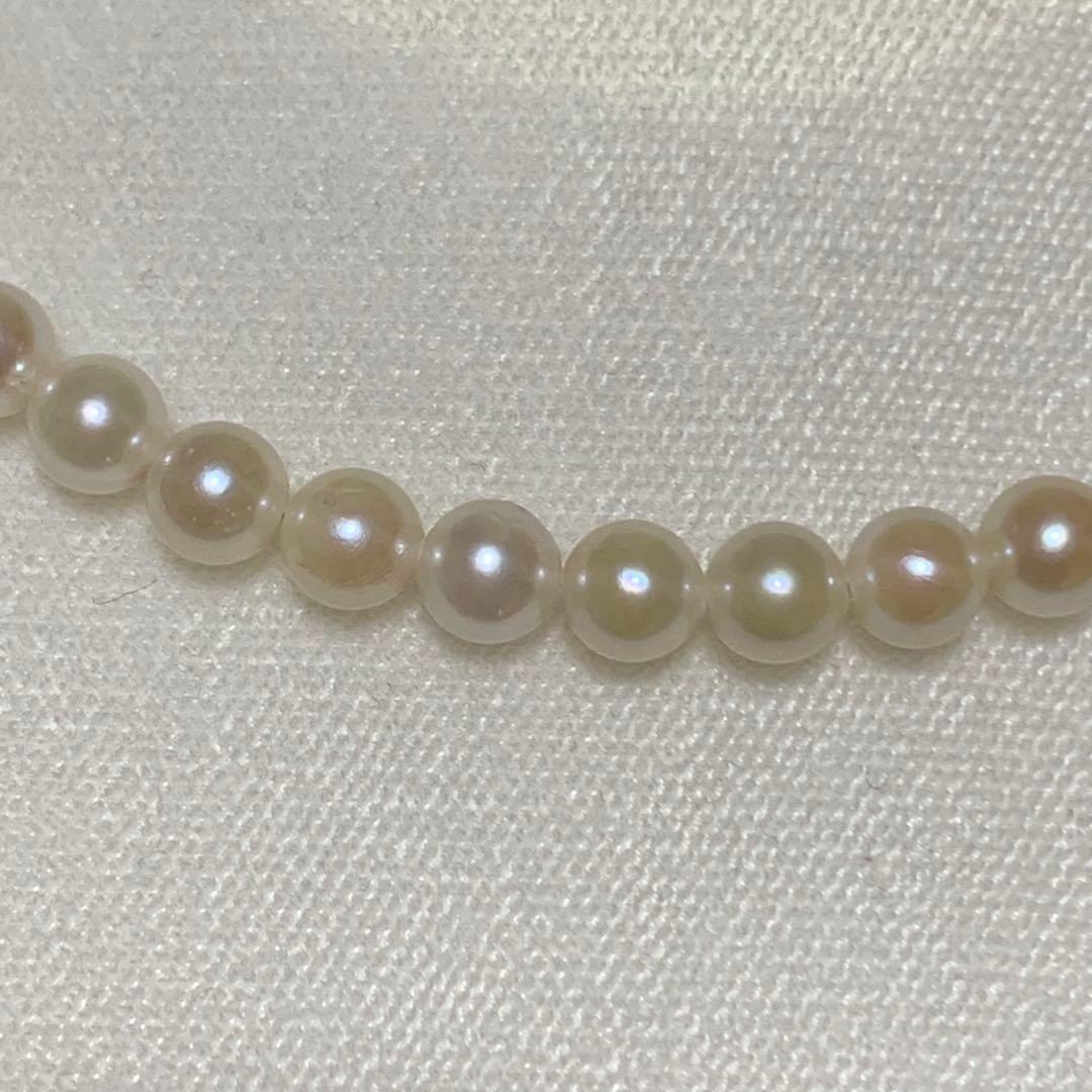 Akoya pearl necklace with 43 cm length and 6.1 to 5.5 mm round pearls on white background