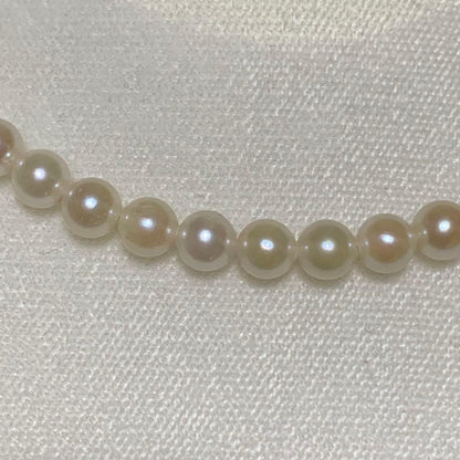 Akoya pearl necklace with 43 cm length and 6.1 to 5.5 mm round pearls on white background