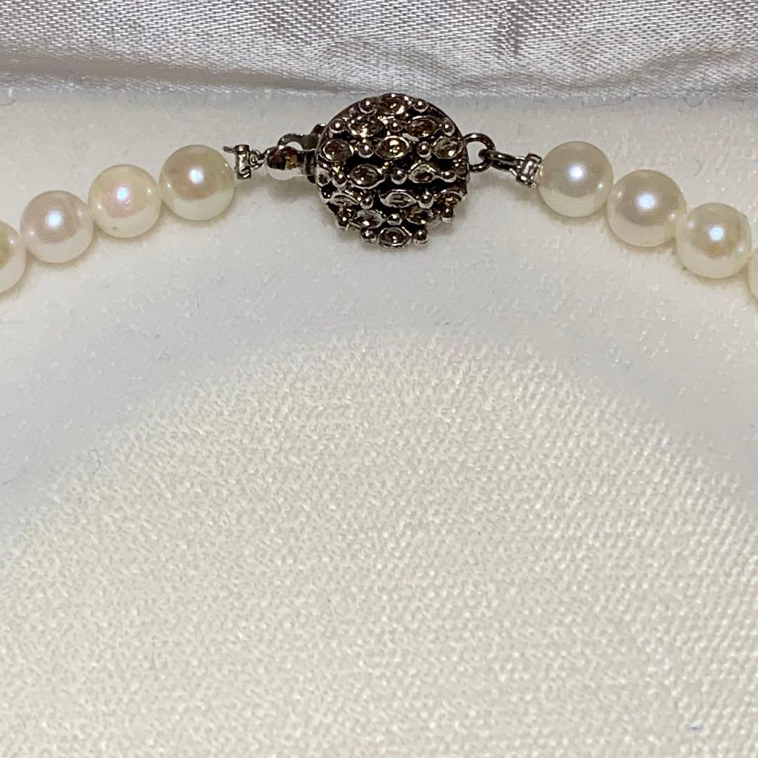 Akoya pearl necklace with 43 cm length and 6.1 to 5.5 mm round pearls on white background